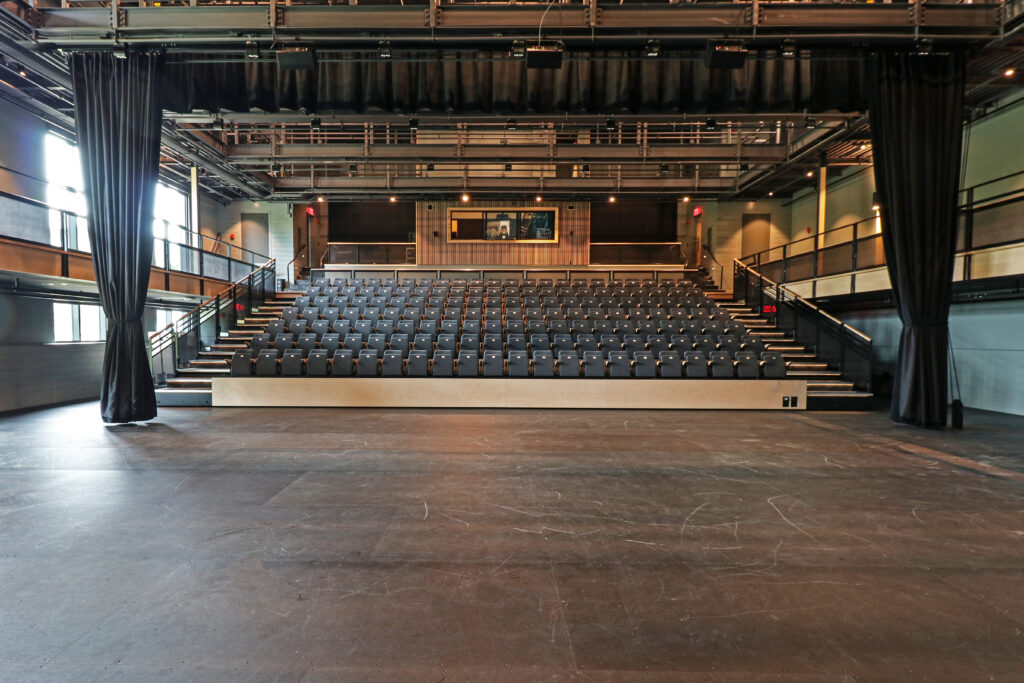 Theater space with retractable seats facing the stage.