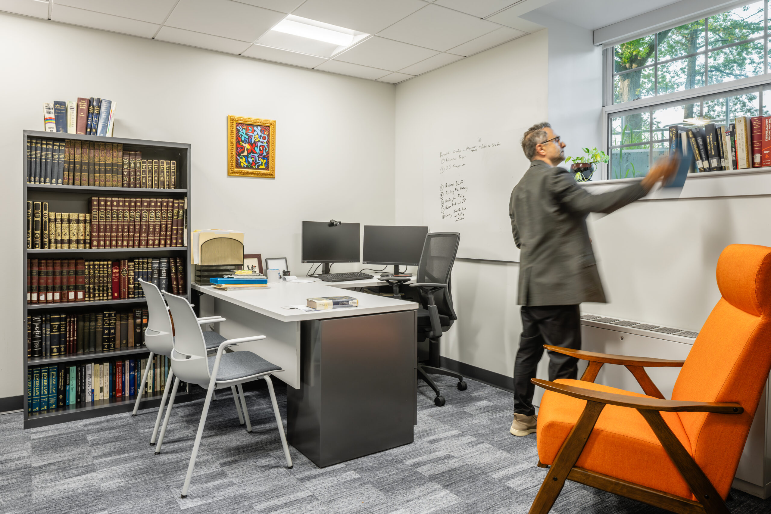 Tufts Eaton Hall Faculty office setup with a book shelf and a des with monitors on top